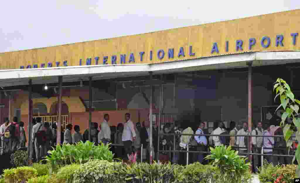 People stand in line at the Roberts International Airport as they leave Liberia, with fear of the Ebola virus spreading in the city of Monrovia, Liberia, Aug. 24, 2014.