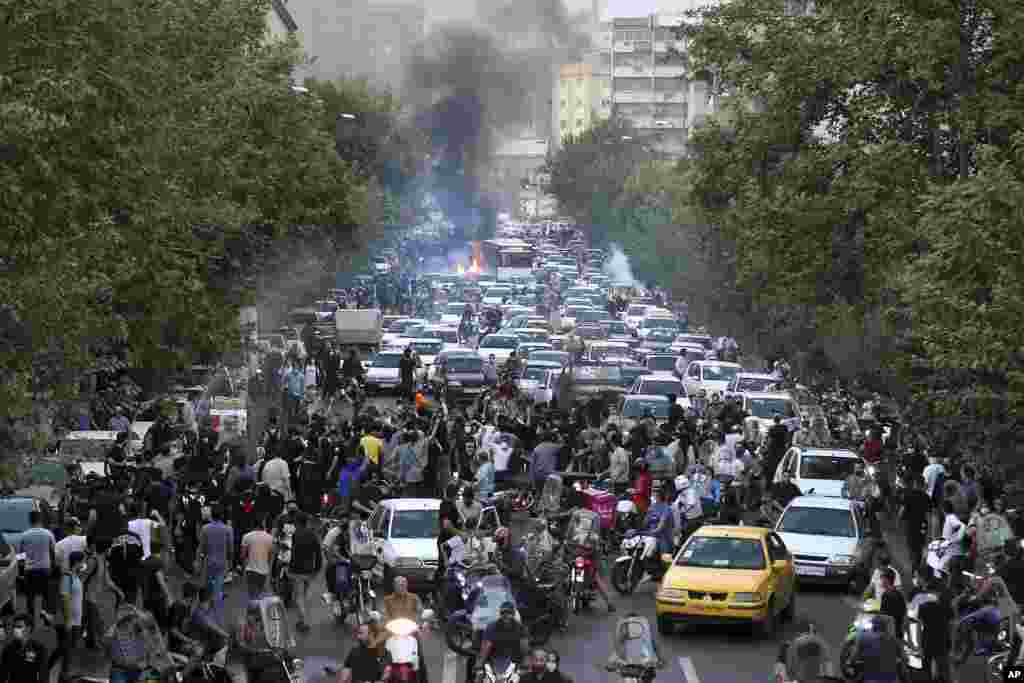 In this Sept. 21, 2022, photo taken by an individual not employed by the Associated Press and obtained by the AP outside Iran, demonstrators block a street during a protest over the death of a woman who was detained by the country's morality police, in downtown Tehran.