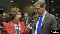 European Union foreign policy chief Catherine Ashton talks with German Foreign Minister Guido Westerwelle at the start of a European Union foreign ministers meeting at the EU Council in Brussels, December 10, 2012.