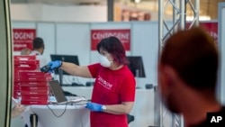 An employee scans coronavirus tests at the airport in Frankfurt, Germany, Friday, Aug. 7, 2020