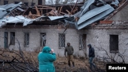 俄羅斯週四飛彈襲擊烏克蘭第聶伯羅市，居民走在一棟被炸毀的房子前。 （2024年11月21日）