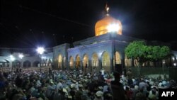 FILE - Syrian Shiites pray outside the shrine of Sayyida Zeinab in Damascus, June 28, 2016. Syria's de facto government said on Jan. 11, 2025, that it had averted a plan by the Islamic State to bomb the shrine.