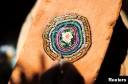 Ben Wilson, shows his painting on a piece of chewing gum, stuck on a brick, in his home studio in Muswell Hill, London, Britain, August 21, 2023. (REUTERS/Anna Gordon)