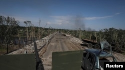 FILE - Members of a foreign volunteers unit which fights in the Ukrainian army drive on a military vehicle, as Russia's attack on Ukraine continues, in Sievierodonetsk, Luhansk region Ukraine, June 2, 2022.