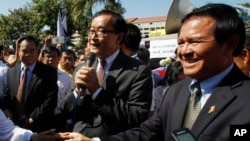 FILE PHOTO - Opposition leader of Cambodia National Rescue Party Sam Rainsy, center, delivers a speech next to his Deputy President Kem Sokha, right, during a gathering to mark Human Rights Day, in front of National Assembly, in Phnom Penh, Cambodia, Wednesday, Dec. 10, 2014. (AP Photo/Heng Sinith)