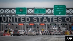 FILE - Cars wait in line to enter the United States at a border crossing at the Canada-U.S. border in Blackpool, Quebec, Canada, on Feb. 2, 2025. 