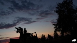 A volunteer for an air defense unit stands by a machine gun used to intercept Russian drones, near Bucha, Kyiv region, Ukraine, Aug. 9, 2024.