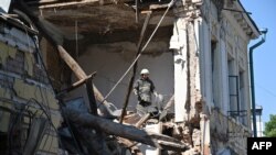 A rescuer works among ruins of an administrative building destroyed by Russian missiles in Kharkiv on July 6, 2022.