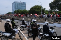 Police look on as Ghanaians march in the streets on the second day of protests over recent economic hardships, in Accra, Ghana, June 29, 2022.