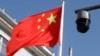 Sebuah kamera pengawas keamanan berada di sebelah bendera China yang berkibar di dekatnya di Beijing, China, 25 November 2021. (Foto: REUTERS/Carlos Garcia Rawlins)