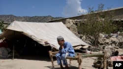 An Afghan child sits in a courtyard of a destroyed home after an earthquake in Gayan district in Paktika province, Afghanistan, June 26, 2022. 