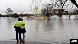 People look at a flooded park due to torrential rain in the Camden suburb of Sydney, Australia, July 3, 2022.