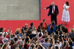 President Donald Trump, walking with first lady Melania Trump, waves to the crowd after speaking at an Independence Day celebration in front of the Lincoln Memorial in Washington, July 4, 2019.