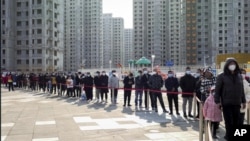 Stanovnici kineskog grada Tjenđina čekaju u redu da se testiraju na kovid (Foto: Chinatopix Via AP)