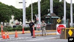 Personal de seguridad monta guardia frente a la entrada de la Base Conjunta de Pearl Harbor-Hickman en Hawái.