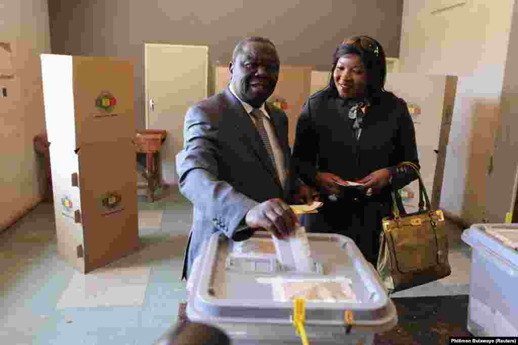 Zimbabwean opposition Movement For Democratic Change (MDC) leader Morgan Tsvangirai (L) casts his vote with his wife Elizabeth in Harare, July 31, 2013. Zimbabweans voted on Wednesday in a fiercely contested election pitting President Robert Mugabe agains