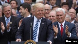 លោក​ប្រធានាធិបតី Donald Trump ប្រមូល​ផ្តុំ​ជាមួយ​នឹង​លោក​អនុប្រធានាធិបតី Mike Pence និង​តំណាងរាស្ត្រ​របស់​គណបក្ស​សាធារណដ្ឋ​នៅ​ក្នុង​សួន​កុលាប​នៃ​សេតវិមាន បន្ទាប់​ពី សភា​តំណាងរាស្ត្រ​អនុម័ត​ច្បាប់ American Healthcare Act ដើម្បី​ជំនួស​ផ្នែក​សំខាន់ៗ​នៃ​ច្បាប់ Obamacare នៅ​ក្នុង​រដ្ឋធានី​វ៉ាស៊ីនតោន កាលពី​ថ្ងៃទី៤ ខែឧសភា ឆ្នាំ២០១៧។