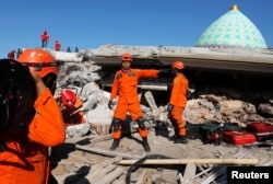 Rescue team members prepare to find people trapped inside a mosque after an earthquake hit on Sunday in Pemenang, Lombok Island, Indonesia, August 8, 2018. REUTERS/Beawiharta