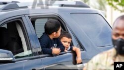 Josué Moreno y su hermano Javier esperan a que miembros de la Guardia Nacional de Washington entreguen a su familia una ración de comida. [Archivo]