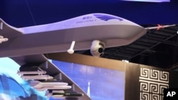 A model of a Wing Loong II weaponized drone hangs above the stand for the China National Aero-Technology Import & Export Corp. at a military drone conference in Abu Dhabi, United Arab Emirates, Feb. 25, 2018.