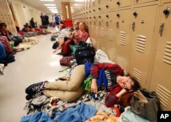 Emily Hindle lies on the floor at an evacuation shelter set up at Rutherford High School, in advance of Hurricane Michael, which is expected to make landfall today, in Panama City Beach, Fla., Wednesday, Oct. 10, 2018. (AP Photo/Gerald Herbert)