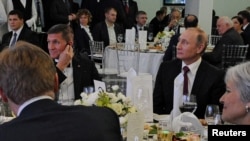 FILE - Russian President Vladimir Putin (R) sits next to retired U.S. Army Lieutenant General Michael Flynn (L) as they attend an exhibition marking the 10th anniversary of RT (Russia Today) television news channel in Moscow, Russia, Dec.10, 2015.