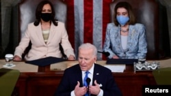 U.S. Vice president Kamala Harris and Speaker of the House Nancy Pelosi listen as U.S. President Joe Biden addresses to a joint session of Congress in the House chamber of the U.S. Capitol in Washington, U.S., April 28, 2021.