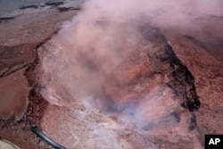 In this photo released by U.S. Geological Survey, a plume of ash rises from the Puu Oo vent on Hawaii's Kilaueaa Volcano, May 3, 2018 in Hawaii Volcanoes National Park.