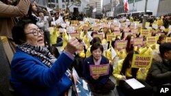 In this March 1, 2017, file photo, former "comfort woman" Lee Yong-soo, left, who was forced to serve for the Japanese troops as a sex slave during World War II, shouts slogans during a rally to mark the March First Independence Movement Day. (AP Photo/Ahn Young-joon, File)