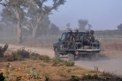 FILE - Members of the Cameroonian Rapid Intervention Force patrol, March 21, 2019, on the outskirt of Mosogo in the far north region of the country where Boko Haram jihadist have been active since 2013.