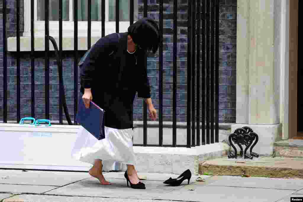 Britain's Lord Chancellor and Secretary of State for Justice Shabana Mahmood retrieves her shoe after losing it from her foot, outside 10 Downing Street in London.
