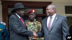 FILE - South Sudanese President Salva Kiir, left, and Vice President Riek Machar shake hands after meetings in Juba, South Sudan, on Oct. 20, 2019, to discuss outstanding issues to a peace deal.