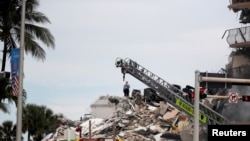 Kikundi cha uokoaji kinaendelea kutafuta wakazi wa jengo ambalo liliporomoka upande mmoja, karibu na Pwani ya Miami, Florida, Marekani., June 24, 2021.