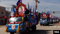 ការដង្ហែរ​ក្បួន​ឃោសនា​រក​សម្លេង​ឆ្នោត​របស់​គណបក្ស​ប្រជាជន​កម្ពុជា ដែល​មាន​រថយន្ត​និង​ម៉ូតូ​ដែល​មាន​ដោត​ទង់ជាតិ​នៃ​ព្រះរាជាណាចក្រ​កម្ពុជា​និង​ទង់​គណបក្ស​រូប​ទេវតា​បាច​ផ្កា​នៅ​ចំ​កណ្តាល​ផ្ទាំង​ក្រណាត់​ពណ៌​ផ្ទៃមេឃ។