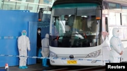 Timu ya wataalam kutoka Shirika la Afya Ulimwenguni -WHO ilipelekwa China kuchunguza asili ya janga la COVID-19 wakipanda basi kabla ya kuondoka uwanja wa ndege wa Wuhan Tianhe, Wuhan, jimbo la Hubei,
China Januari 14, 2021.REUTERS/Thomas Peter