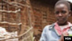 A Girl at the Bethel Outreach Children's Center in the Nairobi slum of Kibera holds up her Peepoo toilet next to a garden fertilized by human waste, April 4, 2012. J. Craig/VOA