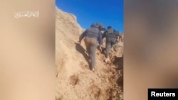 Militanti Hamasa penju se na brdo na lokaciji navedenoj kao Juhr Al-Dik, Gaza, na ovoj fotografiji iz videa za koju se tvrdi da je od 15. decembra 2023. Neki kineski vlogeri prikazuju Hamas kao herojskog i sposobnog na bojnom polju. Vojno krilo Hamasa preko REUTERS-a.