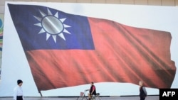 រូបឯកសារ៖ ពលរដ្ឋដើរកាត់ទង់ជាតិ​កោះតៃវ៉ាន់​នៅទីក្រុងតៃប៉ិថ្មី កាលពីថ្ងៃទី១៣ ខែមករា ឆ្នាំ២០២៤។