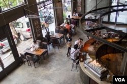 A typical busy day at Coffee Brown Roastery, where working and meeting in a coffee shop is in trending now in Phnom Penh. (Nov Povleakhena/VOA Khmer)