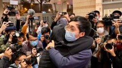 有被告家屬得知保釋申請被拒絕，在法院大樓外抱著元朗區議員林進痛哭（攝影：美國之音湯惠芸）