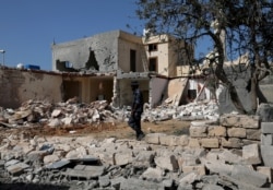 A security member inspects the site of an overnight air strike, which hit a residential district in Tripoli, Libya, Oct. 14, 2019.