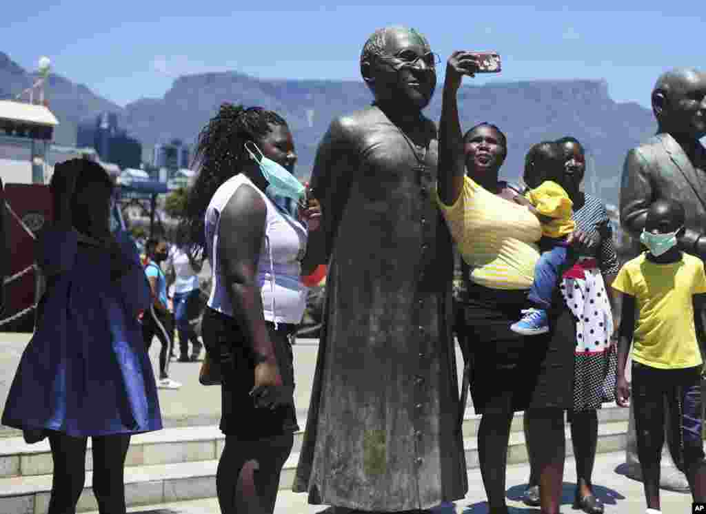 People take photos at a statue of Anglican Archbishop Desmond Tutu at the V&amp;A Waterfront in Cape Town, South Africa.&nbsp;South Africa's president says Tutu, the country's Nobel Peace Prize-winning activist for racial justice and LGBT rights and the retired Anglican Archbishop of Cape Town, has died at the age of 90.