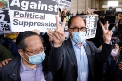 被告之一的何俊仁(左)与民主党前主席杨森离开法院向记者发表声明