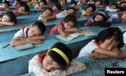 Para pelajar etnis minoritas tidur siang di meja masing-masing setelah istirahat makan siang di sebuah SD di Prefektur Otonomi Kizilsu Kirgiz, Xinjiang, Wilayah Otonomi Uighur, 5 Juni 2012.