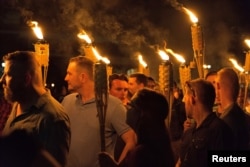 White supremacists carry torches on the grounds of the University of Virginia, on the eve of a planned "Unite the Right" rally in Charlottesville, Virginia, Aug. 11, 2017.