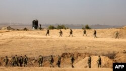 Sejumlah tentara Israel berjalan di sekitar area perbatasan antara Jalur Gaza dan Sderot di selatan Israel, pada 27 Oktober 2023. (Foto: AFP/Jack Guez)