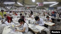 FILE - Laborers work at a garment factory in Bac Giang province, near Hanoi, Oct. 21, 2015. Vietnam's textiles and footwear would gain strongly from the Trans-Pacific Partnership, after exports of $31 billion last year for brands such as Nike, Adidas, H&M