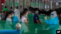 រូប​ឯកសារ៖ បុគ្គលិកសុខាភិបាលថៃកំពុងធ្វើតេស្តរកជំងឺកូវីដ១៩ លើពលករចំណាកស្រុកនិងក្រុមគ្រួសាររបស់ពួកគេ នៅកន្លែងធ្វើតេស្តមួយក្នុងខេត្ត Samut Sakhon ភាគខាងត្បូងទីក្រុងបាងកក ប្រទេសថៃ កាលពីថ្ងៃទី៤ ខែមករា ឆ្នាំ២០២១។