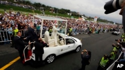 Pope Francis waves from his popemobile as he arrives to offer a giant outdoor mass in Medellin, Colombia, Sept. 9, 2017.