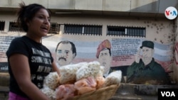 Una comerciante pasa por una calle de Managua. [Foto: Houston Castillo, VOA].